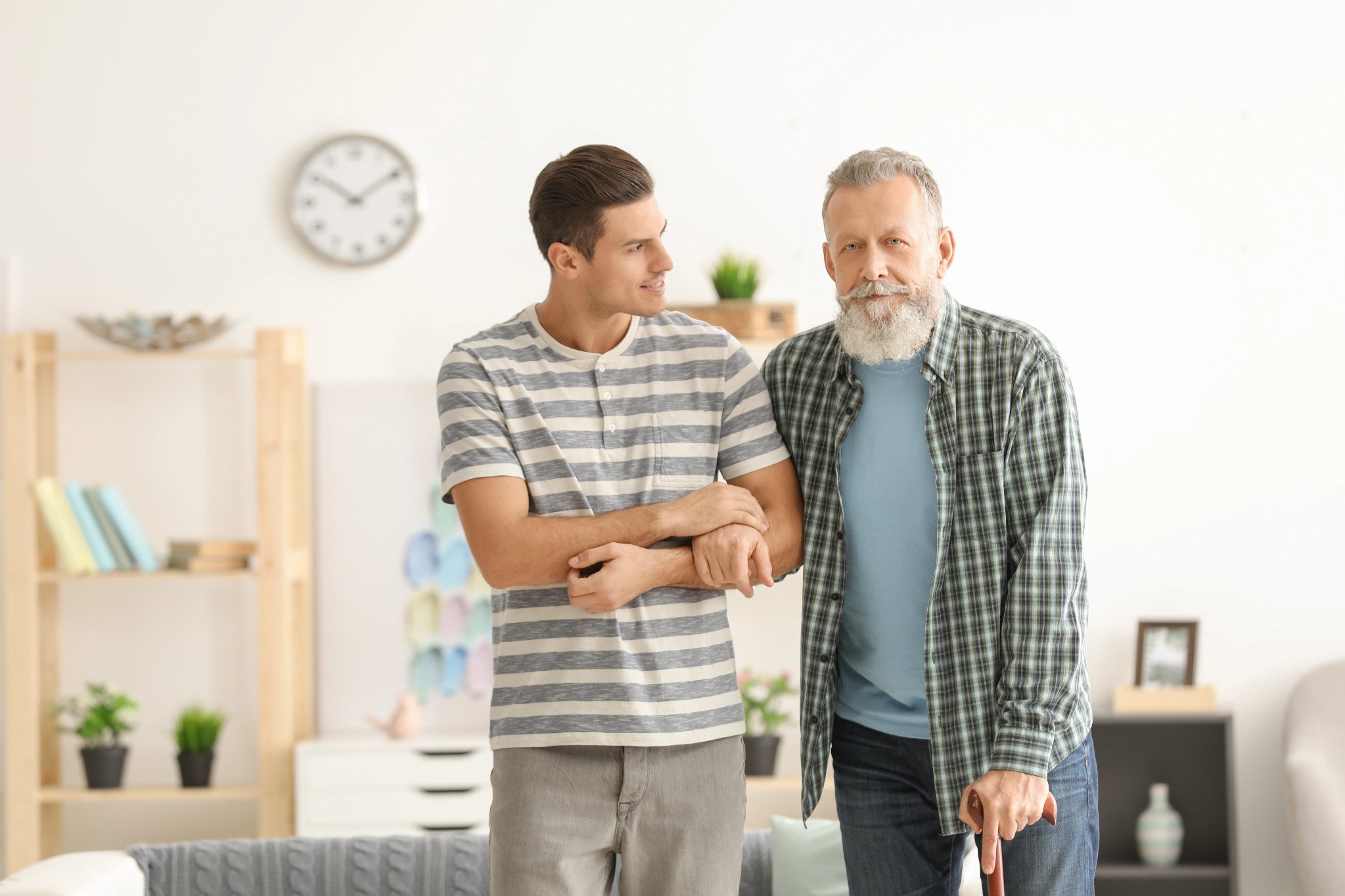 young man helping an old guy walk
